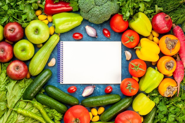 Vista superior de la composición vegetal con frutas frescas en el color de escritorio azul ensalada de dieta madura comida de vida saludable