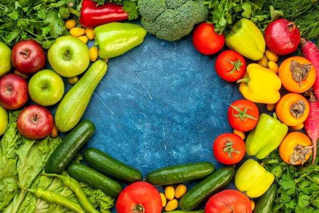 Vista superior de la composición vegetal con frutas frescas en el color de la mesa azul ensalada de dieta madura comida de vida saludable