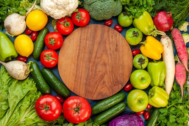 Vista superior de la composición vegetal con frutas frescas en la mesa azul ensalada de comida vida sana dieta de color maduro