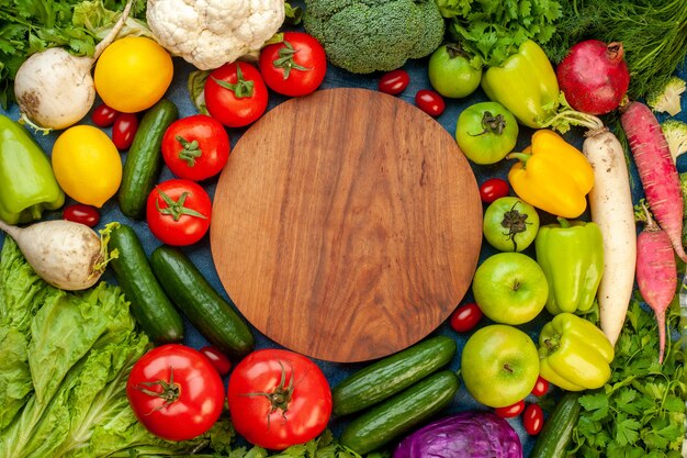 Vista superior de la composición vegetal con frutas frescas en la mesa azul ensalada de comida vida sana dieta de color maduro