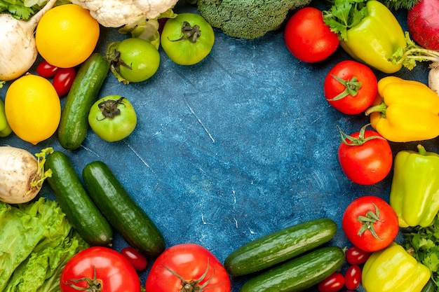 Vista superior de la composición vegetal con frutas frescas en el piso azul, comida, ensalada, vida sana, color maduro