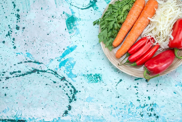 Vista superior composición vegetal repollo zanahorias verdes y pimientos rojos picantes en el escritorio brillante comida vegetal color saludable