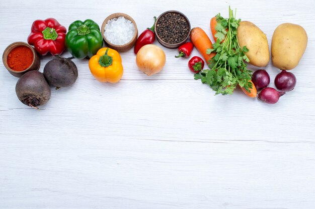 Vista superior de la composición vegetal con verduras frescas verdes frijoles crudos zanahorias y patatas en el fondo claro comida comida ensalada de verduras