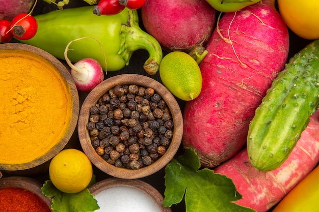 Vista superior de la composición de verduras frescas con condimentos en ensalada madura oscura vida saludable comida dieta color de comida