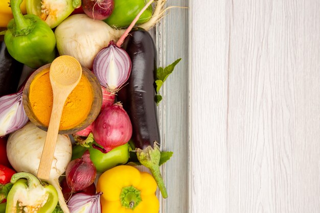 Vista superior de la composición de verduras frescas dentro del marco en la mesa blanca