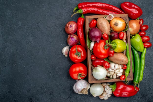 Vista superior de la composición de verduras frescas en ensalada de mesa de color gris oscuro color maduro