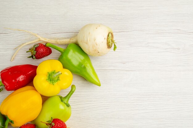 Vista superior de la composición de verduras frescas con frutas sobre fondo blanco.