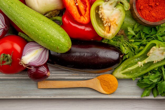 Vista superior de la composición de verduras frescas con verduras y condimentos en la mesa blanca