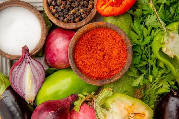 Vista superior de la composición de verduras frescas con verduras y condimentos en la mesa blanca