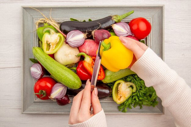 Vista superior de la composición de verduras frescas con verduras dentro del marco en la mesa blanca