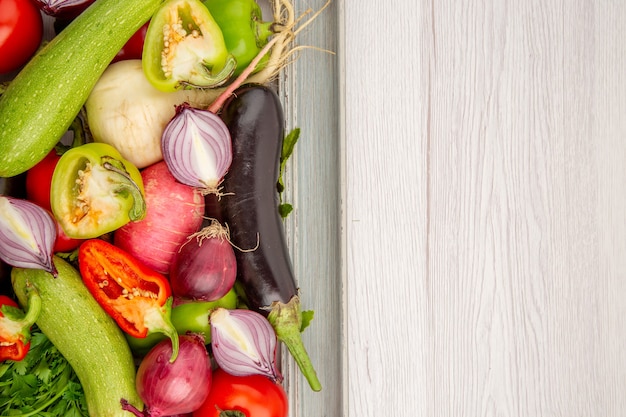 Vista superior de la composición de verduras frescas con verduras en la mesa blanca