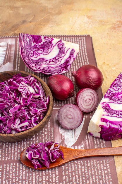 Vista superior de un concepto con cebollas rojas y un tazón de col roja picada para ensalada de verduras caseras frescas con espacio de copia
