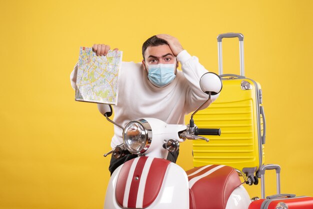Vista superior del concepto de viaje con chico joven en máscara médica de pie cerca de la motocicleta