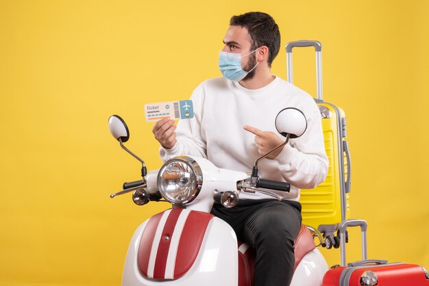 Vista superior del concepto de viaje con chico joven vacilante en máscara médica sentado en motocicleta