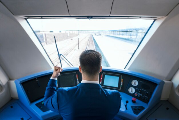 Vista superior del conductor del metro que llega a la estación a tiempo con su tren de alta velocidad