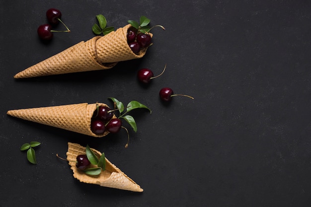 Foto gratuita vista superior conos de helado con cerezas