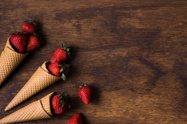 Vista superior conos de helado con fresas