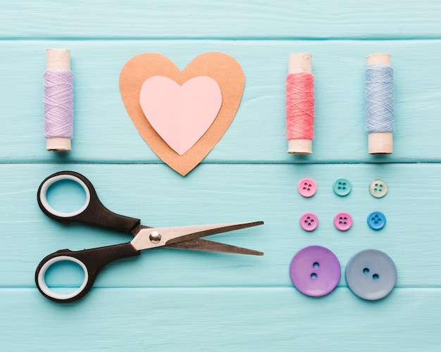 Vista superior del corazón de papel con suministros de costura para el día de San Valentín