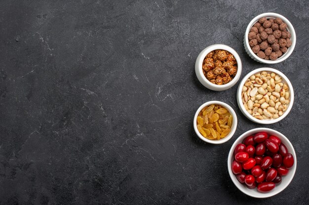 Vista superior cornejos rojos con nueces y pasas sobre fondo gris caramelo azúcar fruta nuez dulce