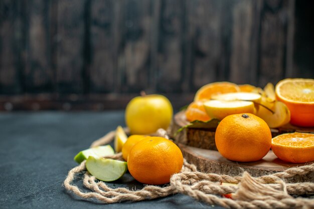 Vista superior cortar manzanas y naranjas en cóctel de tablero de madera sobre fondo oscuro