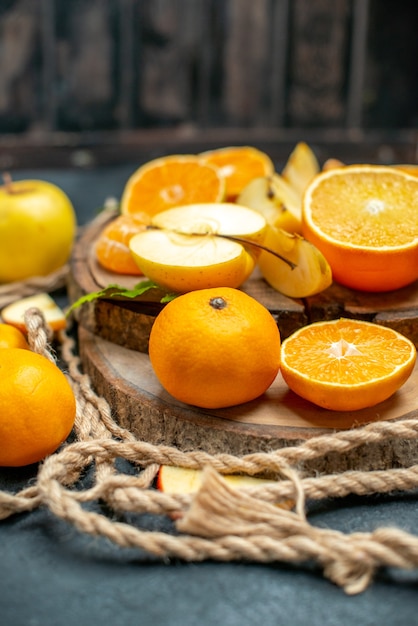 Vista superior cortar manzanas y naranjas en cóctel de tablero de madera sobre fondo oscuro