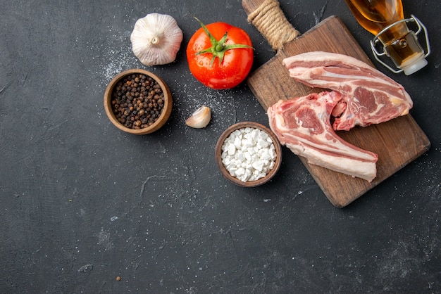 Vista superior de costillas de carne fresca carne cruda con aceite y ajo en barbacoa oscura plato de animales comida de pimienta comida de ensalada de vaca