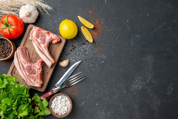 Vista superior de costillas de carne fresca carne cruda con verduras en alimentos oscuros barbacoa plato animal comida comida cocina lugar libre de carne