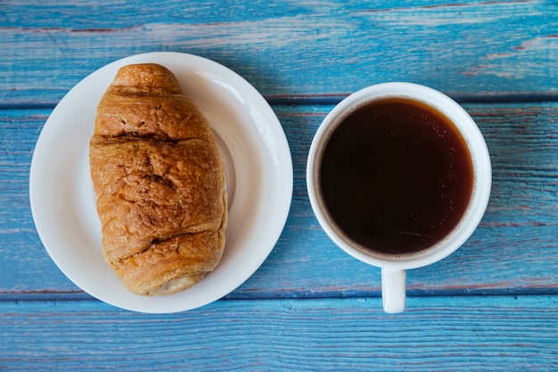 Foto gratuita vista superior croissant y café en mesa de madera