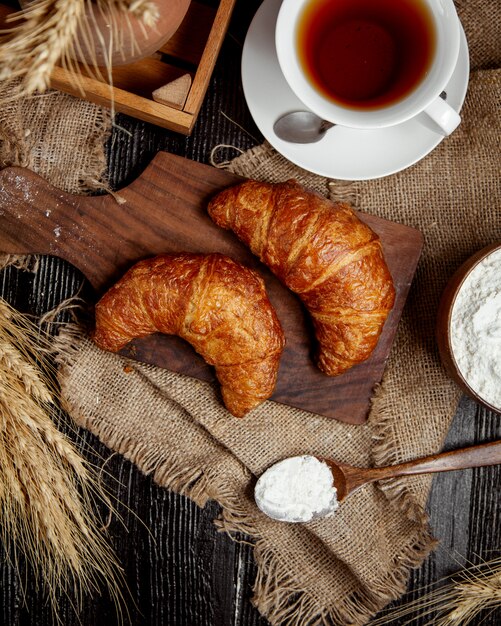 Vista superior de croissants de mantequilla lugares en tablero de madera