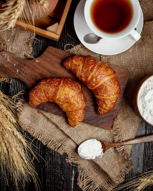 Vista superior de croissants de mantequilla lugares en tablero de madera