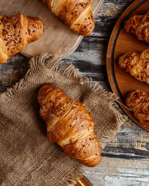 Vista superior de croissants de mantequilla en tela de lino en estilo rústico