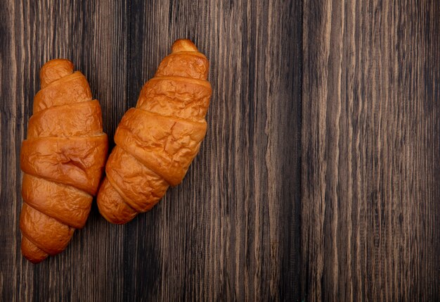 Vista superior de croissants sobre fondo de madera con espacio de copia