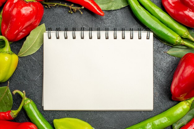 Vista superior del cuaderno en blanco blanco con verduras de otoño sobre una superficie gris con espacio libre