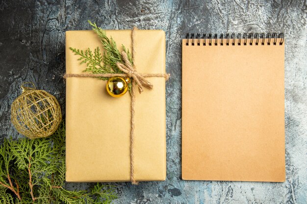 Vista superior del cuaderno de bolas de Navidad de ramas de pino de regalo de Navidad en superficie gris