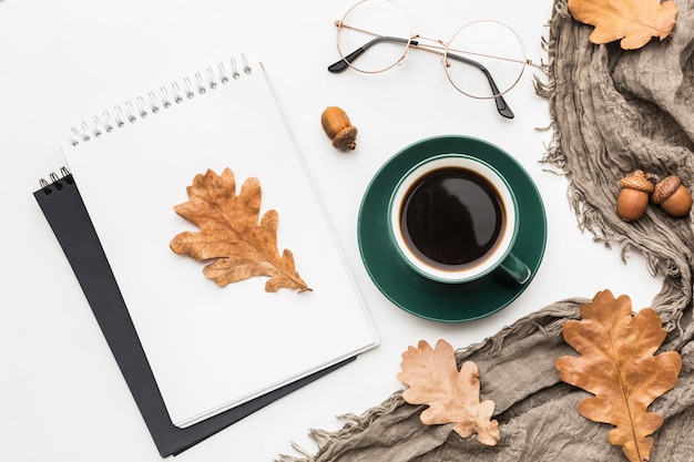 Vista superior del cuaderno con café y hojas de otoño