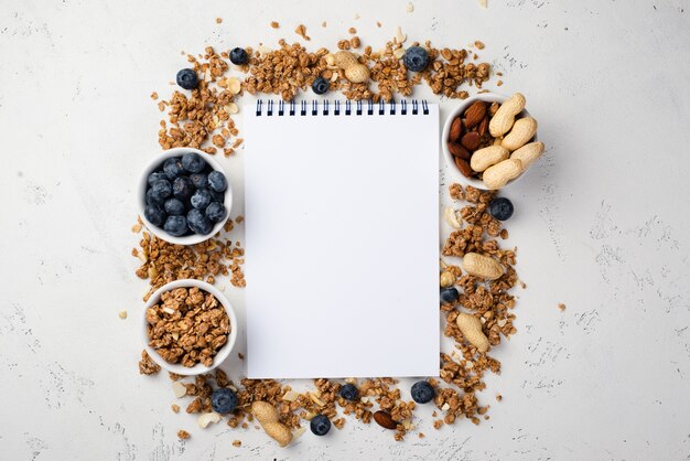 Vista superior del cuaderno con cereales para el desayuno y arándanos