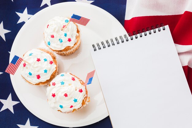 Vista superior del cuaderno con cupcakes y bandera americana
