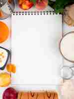 Foto gratuita vista superior de un cuaderno de dibujo con duraznos frescos yogur requesón y mermelada en blanco