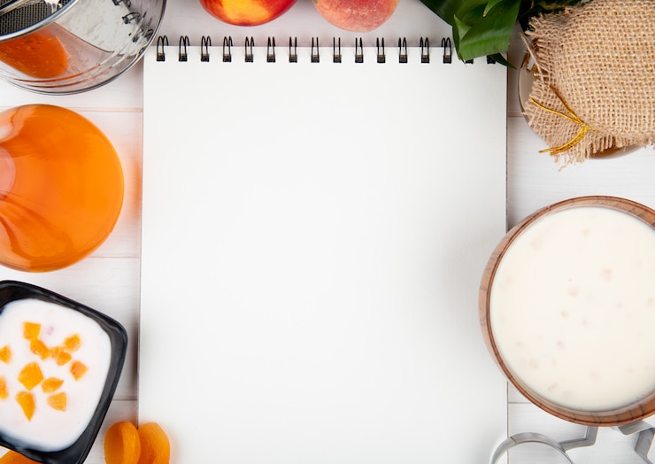 Foto gratuito vista superior de un cuaderno de dibujo con duraznos frescos yogur requesón y mermelada en blanco