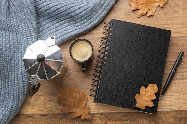 Vista superior del cuaderno con taza de café y hervidor