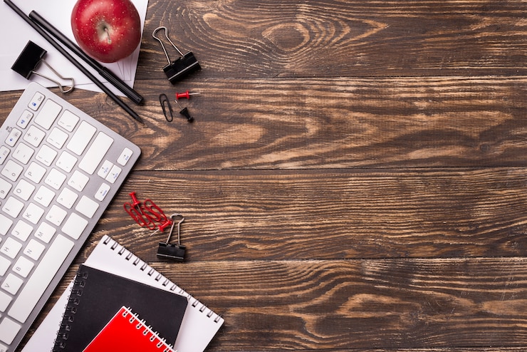 Foto gratuito vista superior de cuadernos y manzana en escritorio de madera con espacio de copia