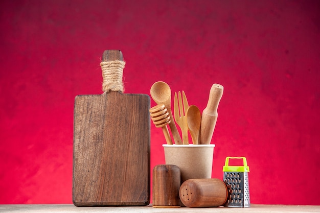 Vista superior de la cuchara de madera en un rallador de tabla de cortar de cafetera de plástico vacía en superficie rosa