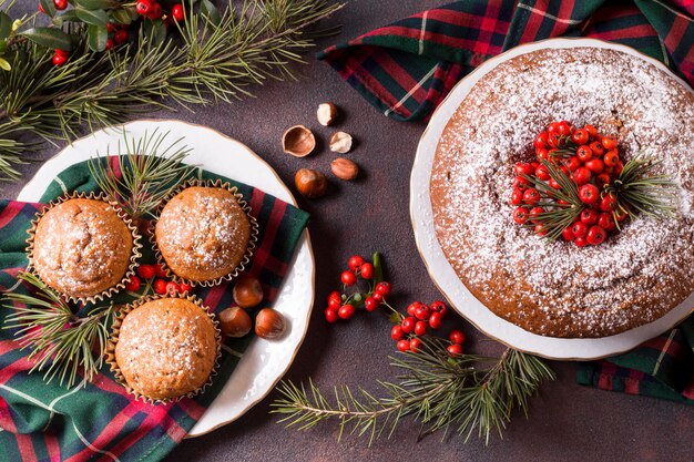Vista superior de cupcakes navideños y pastel con frutos rojos