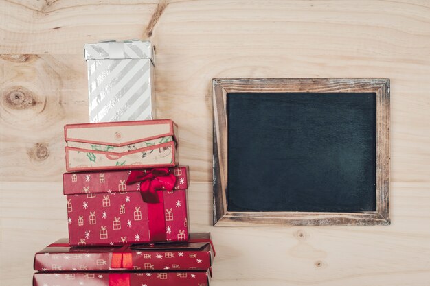 Vista superior de decoración de navidad con pizarra al lado de cajas de regalo