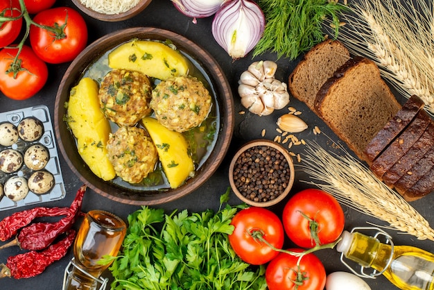 Vista superior de la deliciosa comida de albóndigas verduras frescas picos rebanadas de pan huevos verdes sobre fondo negro