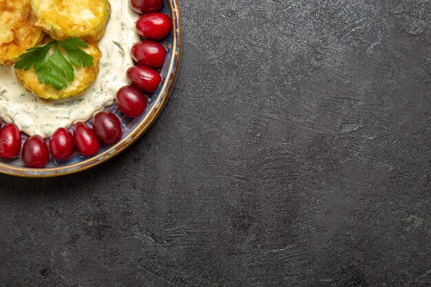 Vista superior de la deliciosa comida de calabaza con cornejos rojos frescos en la superficie gris