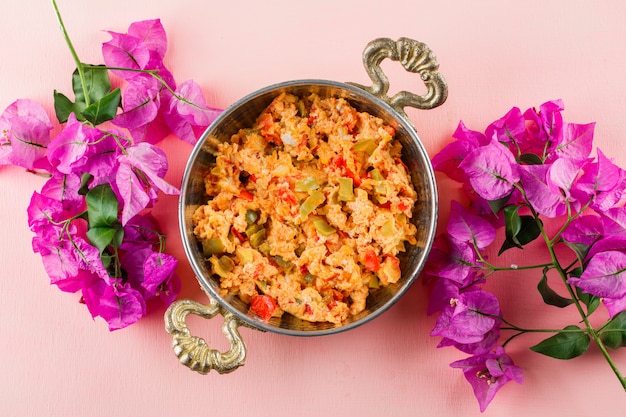 Foto gratuita vista superior deliciosa comida en maceta con flores en superficie rosa