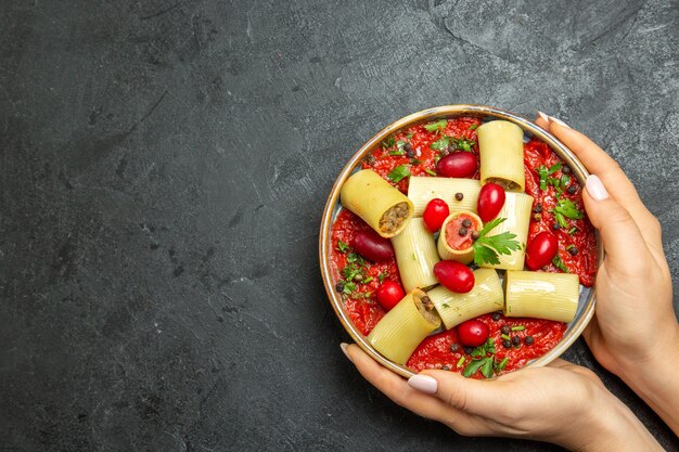 Vista superior de la deliciosa comida de pasta italiana cocida con carne y salsa de tomate en salsa de carne de masa de pasta de escritorio gris