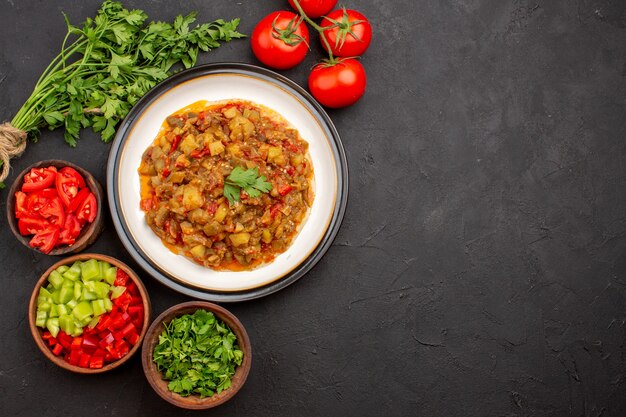 Vista superior deliciosa comida vegetal en rodajas plato cocido dentro de la placa en el escritorio gris comida cena comida salsa sopa vegetal