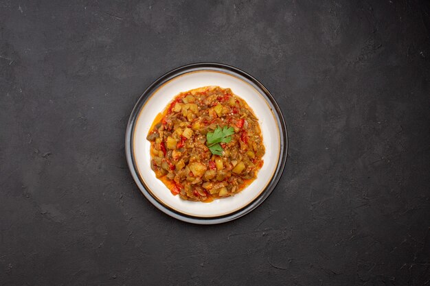 Vista superior deliciosa comida vegetal en rodajas plato cocido dentro de la placa sobre el fondo gris cena comida comida salsa sopa
